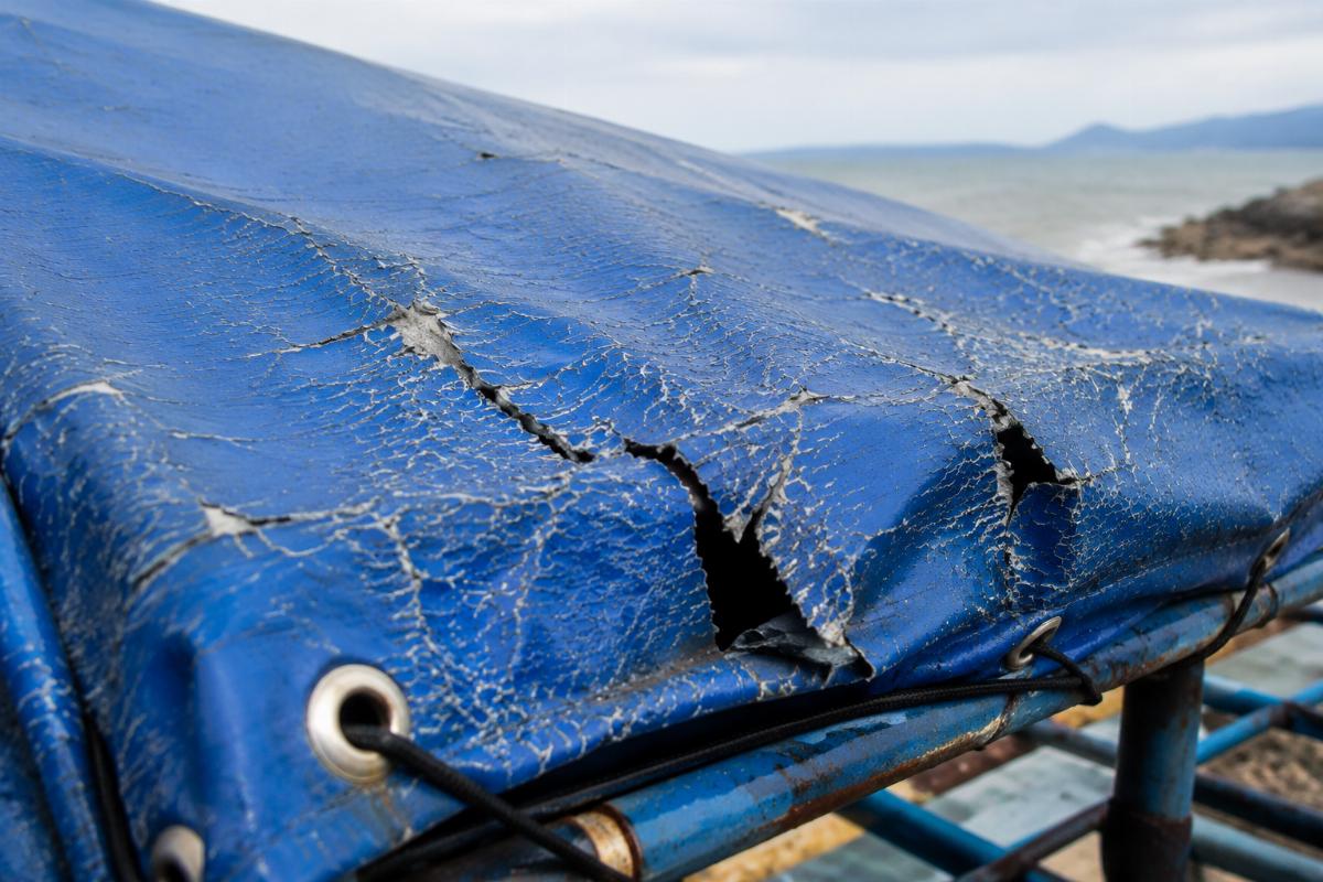 Ordinary PVC tarpaulin showing cracking and tearing after 6 months of coastal exposure