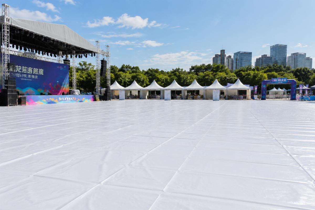 Outdoor event site covered with neatly laid PVC ground sheets